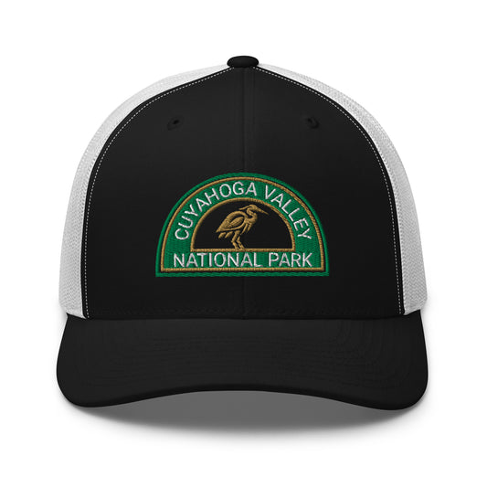 Cuyahoga Valley National Park Hat with a half moon embroiderd patch in Green and Sandstone featuring a Blue Heron on a Yupoong 6606 Black/White Hat - front view.
