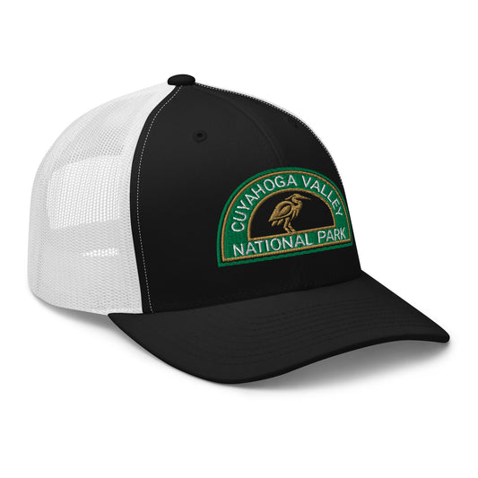 Cuyahoga Valley National Park Hat with a half moon embroiderd patch in Green and Sandstone featuring a Blue Heron on a Yupoong 6606 Black/White Hat - side view.