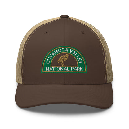 Cuyahoga Valley National Park Hat with a half moon embroiderd patch in Green and Sandstone featuring a Blue Heron on a Yupoong 6606 Brown/Khaki Hat - front view.