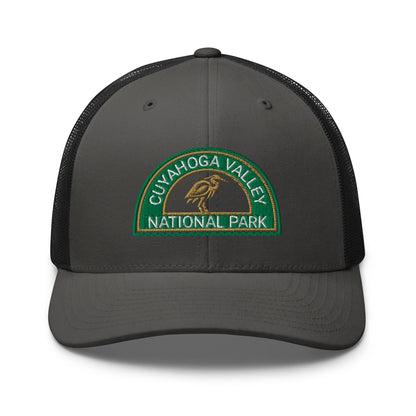 Cuyahoga Valley National Park Hat with a half moon embroiderd patch in Green and Sandstone featuring a Blue Heron on a Yupoong 6606 charcoal/black Hat - front view.