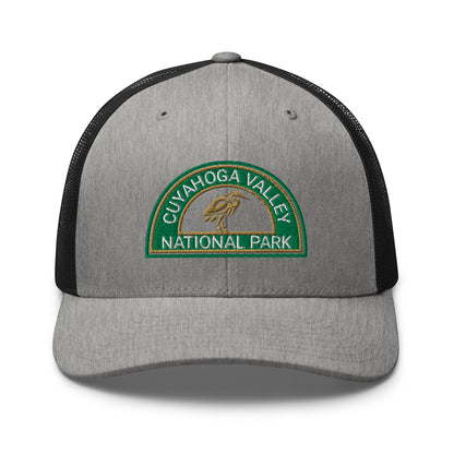 Cuyahoga Valley National Park Hat with a half moon embroiderd patch in Green and Sandstone featuring a Blue Heron on a Yupoong 6606 heather gray/black Hat - front view.