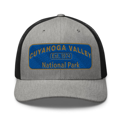 Cuyahoga Valley National Park Hat with a blue and gold embroidered park patch on the front on a Yupoong 6606 heather greay/black trucker hat - front view.