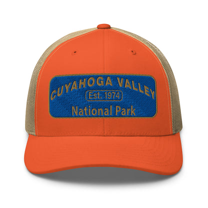 Cuyahoga Valley National Park Hat with a blue and gold embroidered park patch on the front on a Yupoong 6606 orange/khaki trucker hat - front view.
