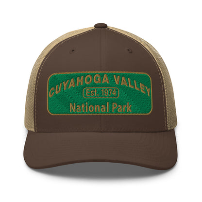 Cuyahoga National Park Hat with a green and gold embroidered national park styled patch on the front of a Yupoong 6606 brown/khaki trucker hat - front view.