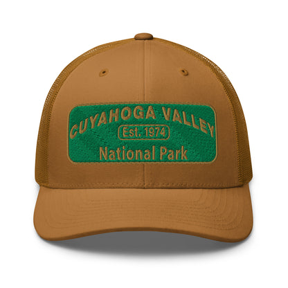 Cuyahoga National Park Hat with a green and gold embroidered national park styled patch on the front of a Yupoong 6606 caramel trucker hat - front view.