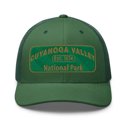 Cuyahoga National Park Hat with a green and gold embroidered national park styled patch on the front of a Yupoong 6606 evergreen trucker hat - front view.