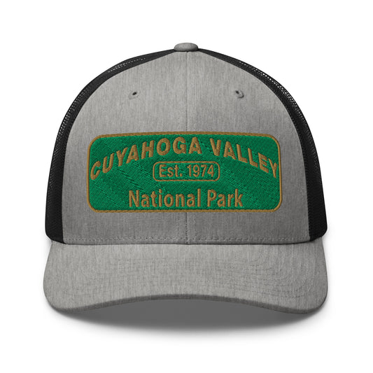 Cuyahoga National Park Hat with a green and gold embroidered national park styled patch on the front of a Yupoong 6606 heather grey/black trucker hat - front view.