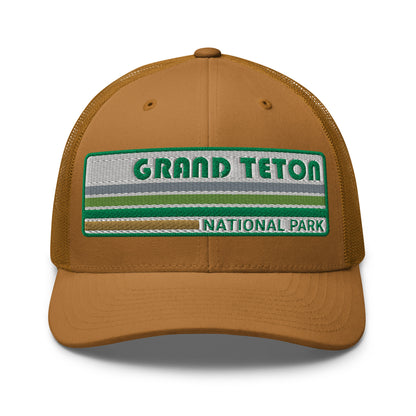 Grand Teton Hat with Retro 70's Style embroidered national park logo. Grand Teton National Park in Green on a caramel Yupoong 6606 Trucker Hat front side view.