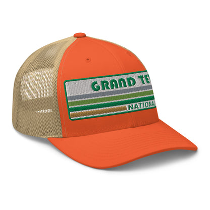 Grand Teton Hat with Retro 70's Style embroidered national park logo. Grand Teton National Park in Green on a orange/khaki Yupoong 6606 Trucker Hat right side view.